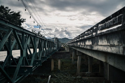 Low angle view of bridge and buildings against sky