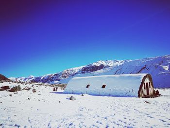 Scenic view of snowcapped mountains against clear blue sky