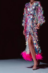 Fashion details of haute couture pink glittering party dress. fashion model on black background