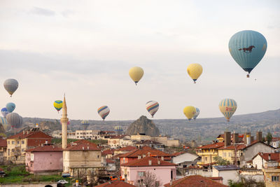 Hot air balloons flying over buildings in city