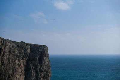 Rock formation in sea against sky