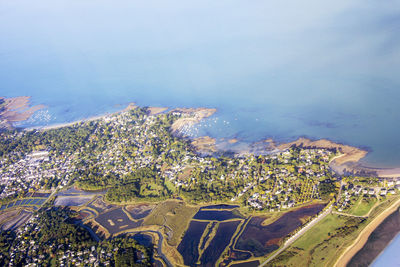 High angle view of cityscape by sea against sky