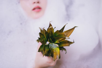 Midsection of woman holding pineapple while bathing