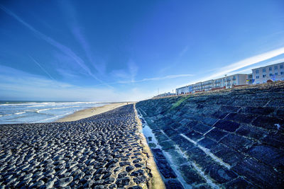 Surrounding wall by sea against sky