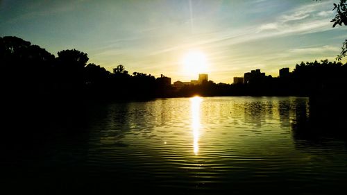 Sunset over river with buildings in background