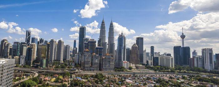 Panoramic view of skyscrapers against cloudy sky