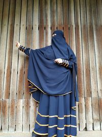 Rear view of person standing against blue wall