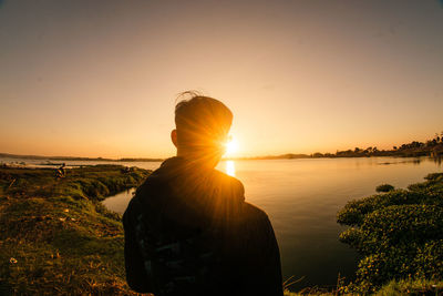 Rear view of man against sky during sunset