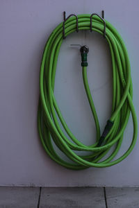 High angle view of green hose against the wall