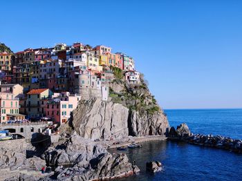 Scenic view of sea by buildings against clear sky