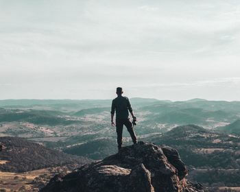 Rear view of man standing on cliff