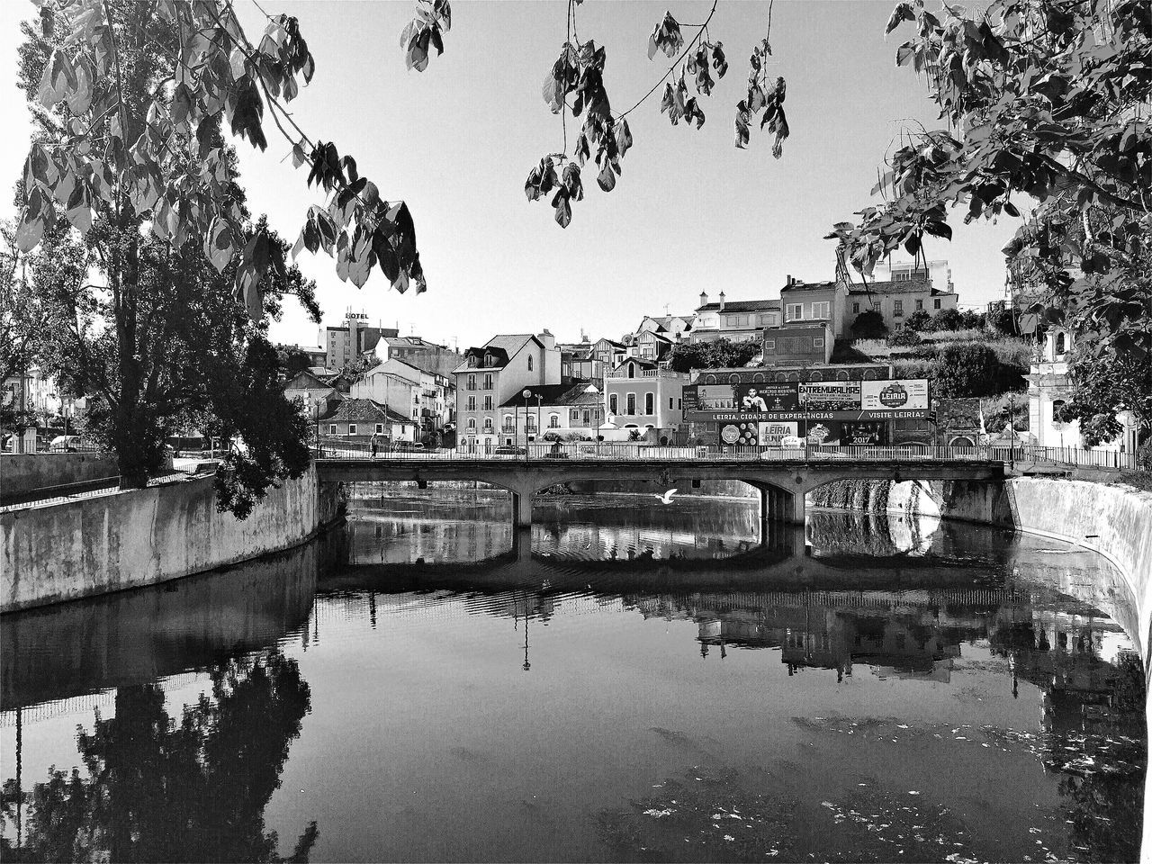 VIEW OF BRIDGE OVER CALM RIVER