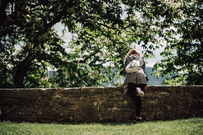 Woman standing by tree against sky