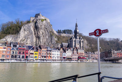 Meuse river waterfront with view of notre dame de dinant church and citadel of dinant