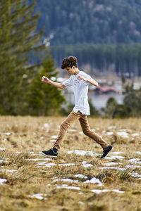 Man jumping on field during winter