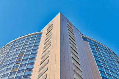 Low angle view of modern building against clear blue sky