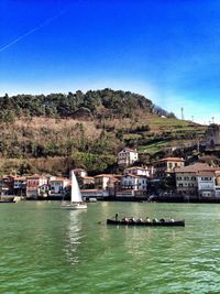 Boats in river with town in background