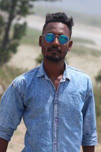 Portrait of man wearing sunglasses standing outdoors