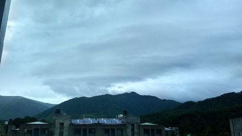 Houses by mountains against sky