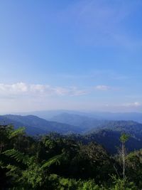 Scenic view of mountains against blue sky