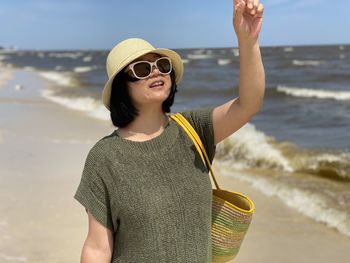 Mid adult man wearing sunglasses standing on beach