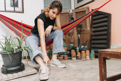 Full length of smiling young woman sitting on staircase