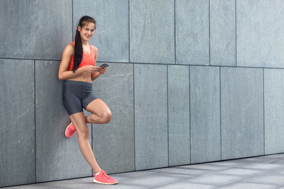 Young woman using mobile phone in city