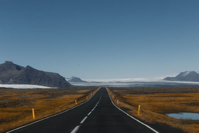 Empty road along countryside landscape