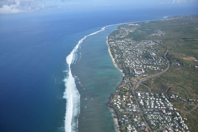 Aerial view of sea and cityscape against sky