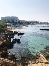 Scenic view of sea and buildings against clear sky