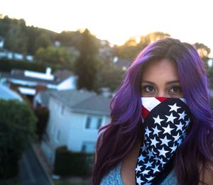 Portrait of beautiful young woman standing against sky