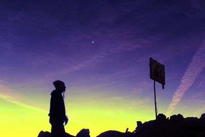 Low angle view of silhouette man against purple sky