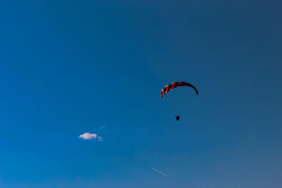 Low angle view of person paragliding against clear blue sky