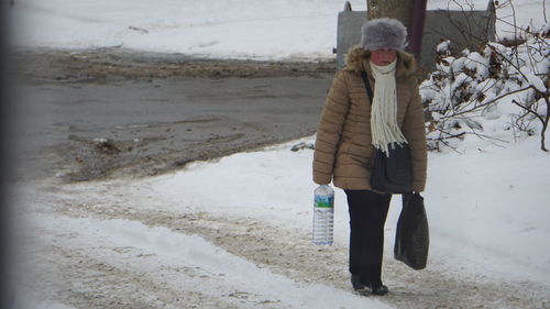 Woman waking on snowy road