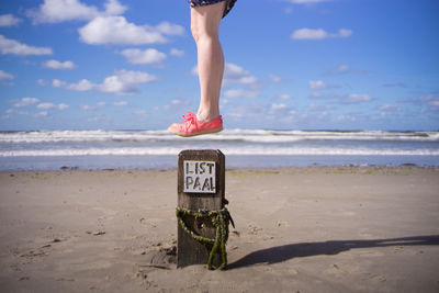 Scenic view of woman jumping at beach