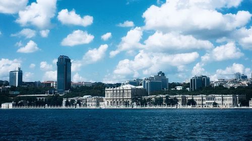 Sea by buildings against sky in city