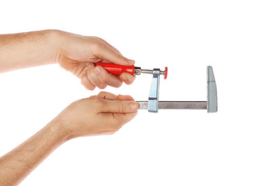 Close-up of hand holding cigarette against white background