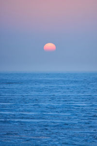 Scenic view of sea against clear sky during sunset