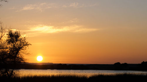 Scenic view of silhouette field against sky during sunset