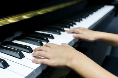 Cropped hands of person playing piano