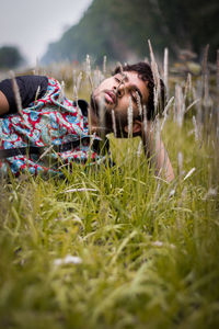 Portrait of woman relaxing on field