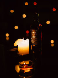 Close-up of lit candle in darkroom