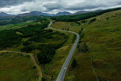 Aerial view of winding road in scotland. beautiful and clean nature with high mountains.
