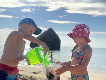 Rear view of mother and daughter at beach