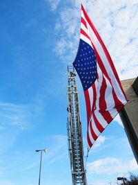 Low angle view of flag against blue sky