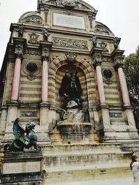 Low angle view of statue against historic building