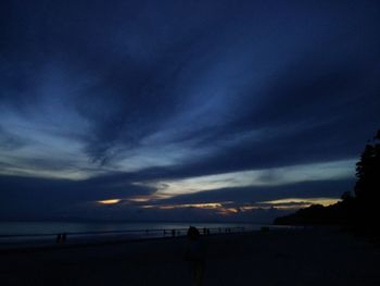 Scenic view of beach against sky at sunset