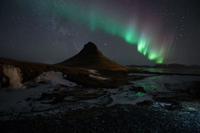 Scenic view of snowcapped mountains against sky at night