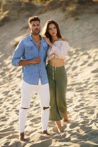 Full length of young couple standing on beach