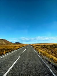 Empty road along countryside landscape